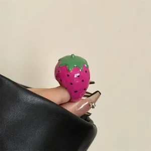 Detailfoto van schattige aardbei ring met emaille, trendy fruit sieraden voor dames.