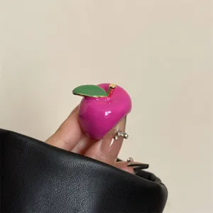Close-up detailopname van de roze fruit emaille ring, toont voortreffelijk handwerk textuur.