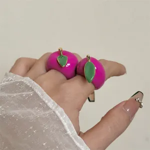 Close-up van helderroze fruit emaille ringen met groene bladeren, prachtig detail.