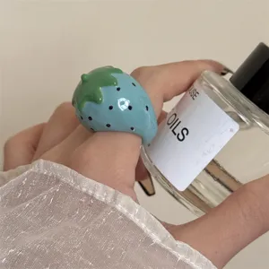 Close-up detail van een schattige blauwe emaillen aardbei ring, macaron stijl mode sieraad.