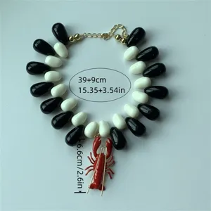 Collier ras du cou pendentif homard tendance avec perles en forme de goutte noir et blanc.