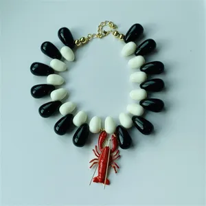 Collier ras de cou pendentif homard tendance avec perles en résine noire et blanche