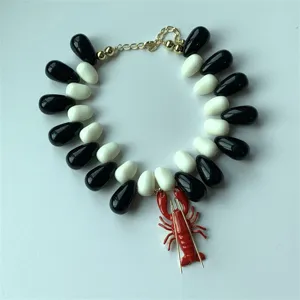 Vue détaillée du collier tendance avec pendentif homard et perles en résine noir et blanc.