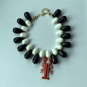 Vue détaillée du collier pendentif homard de mode avec perles en résine noire et blanche.