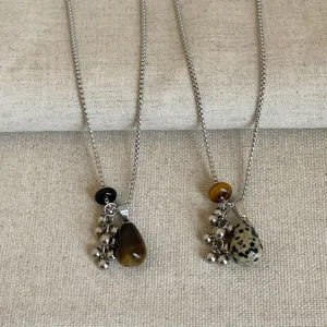 Detailopname van de prachtige natuurstenen hanger en de metalen druiventros ketting.