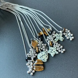 Gedetailleerd overzicht van vintage titanium stalen kettingen met natuurstenen hangers en kralen.
