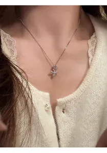 Detailed shot of a delicate silver multi-pendant necklace featuring a sparkling cross charm.