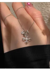 Close-up of the delicate silver Dorje cross pendant necklace with sparkling crystal details.
