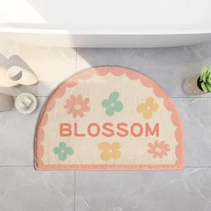 Cute semi-circular bath mat with pastel floral design and soft plush texture for bathroom floor.