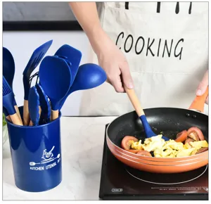 Set di utensili da cucina in silicone con manico in legno e secchiello, vista di dettaglio.