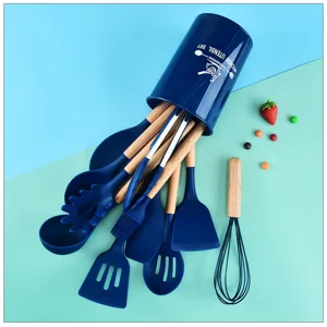 Dettaglio set utensili cucina in silicone con spatola blu, manico legno e secchiello.
