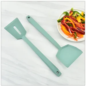 Silicone kitchen spatula detail view, minimalist cooking utensil set on marble surface.