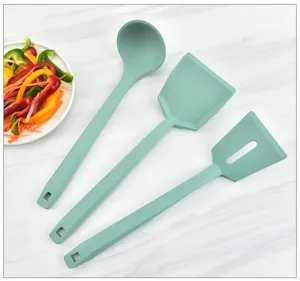 Detail view of green silicone kitchen utensil set, durable cooking spatula and ladle.