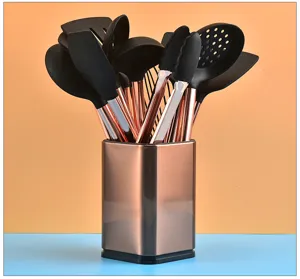 Juego de utensilios de cocina de silicona con mangos de metal oro rosa y soporte.