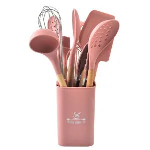 Pink silicone kitchen utensil set with wooden handles in a matching storage holder container.