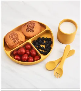 Silicone baby feeding set with divided plate, cup, spoon, and fork in yellow color detail.