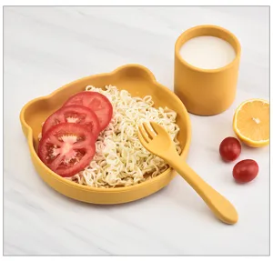 Detailed view of the cute yellow silicone bear bowl, cup, and fork set for baby feeding time.