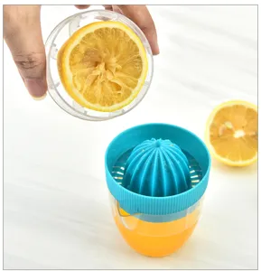 Dettaglio dello spremiagrumi manuale che mostra il processo con tazza trasparente.