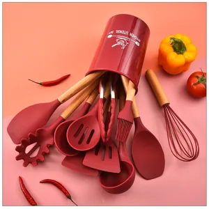 Detailed view of red silicone kitchen utensil set with wooden handles and matching storage bucket.