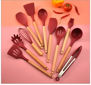 Silicone kitchen utensils set detail showing red spatula, whisk and wooden handles for cooking.
