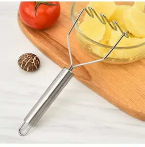 Stainless steel potato masher detail view showing wavy wire head and metal handle.