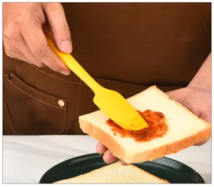 Spatola in silicone vista dettagliata, utensile da forno giallo che spalma la marmellata.