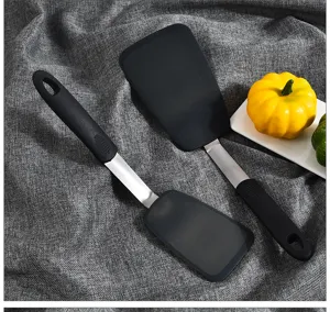Detail view of black silicone spatulas with metal handle and hanging hole for kitchen cooking.