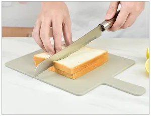 Kunststof snijplank met handvat detail, duurzaam keukengereedschap voor huishoudelijk gebruik.