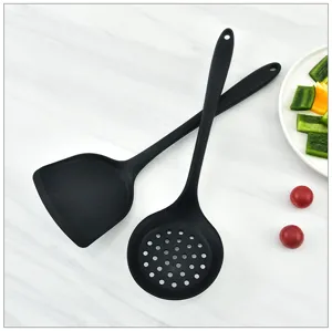 Black silicone kitchen utensil set including spatula and slotted spoon for cooking.