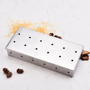 Stainless steel smoker box with twelve holes for outdoor grilling and wood chip smoking.