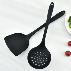 Black silicone kitchen utensil set featuring a spatula and slotted spoon top view display.
