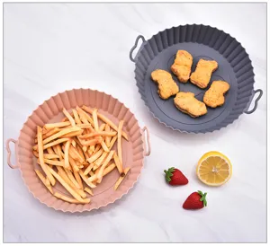Détail de panier de friteuse à air en silicone avec doublures grises et roses avec des aliments.