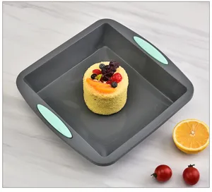 Detail view of the square grey silicone baking pan with mint green handles, ideal for cakes.