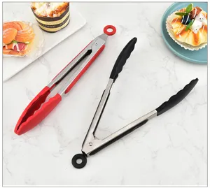 Detail view of stainless steel silicone food tongs with red and black handles, kitchen BBQ.