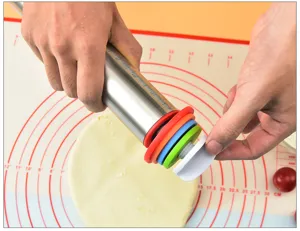 Adjustable stainless steel rolling pin with removable thickness rings and baking mat for kitchen.