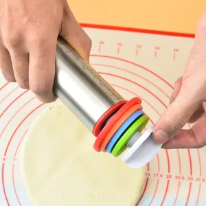 Adjustable stainless steel rolling pin with colorful thickness rings and baking mat scale.