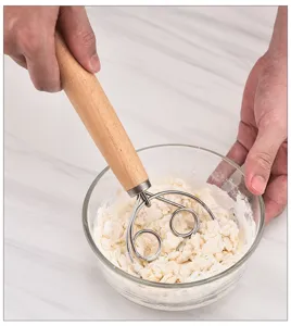 Stainless steel dough whisk with wooden handle for baking and mixing flour smoothly clearly.