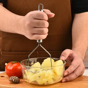 Stainless steel potato masher with wavy design and sturdy handle for kitchen cooking and baby food.