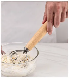 Stainless steel dough whisk with wooden handle, professional baking tool for mixing flour and dough.