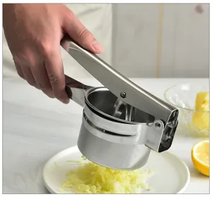 Vue détaillée de presse-purée en acier inoxydable, outil de cuisine manuel pressant des pommes.