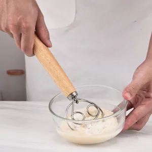 Stainless steel dough whisk with wooden handle, ergonomic flour mixer for baking and pastry.