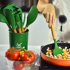 Silikon Küchenutensilien Set mit Holzgriffen und grünem Aufbewahrungsbehälter zum Kochen.