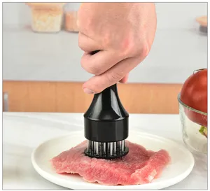 Stainless steel meat tenderizer needle tool detail showing kitchen cooking gadget usage on meat.