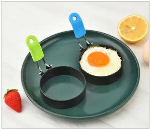 Stainless steel fried egg mold detail view, round breakfast cooking ring with silicone handle.