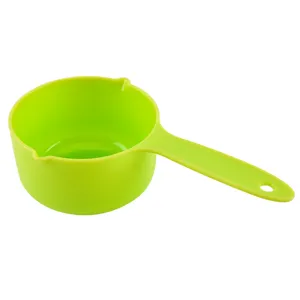 Green plastic measuring cup with dual spouts and long handle for baking and kitchen use.