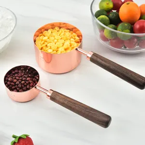 Rose gold measuring cups with wooden handle set, premium baking tools for kitchen use.