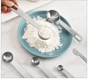 Stainless steel measuring spoons set with clear engraved capacity marks for baking flour use.