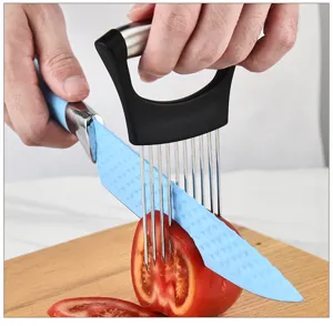 Dettaglio di un supporto per cipolle in acciaio inossidabile mentre taglia un pomodoro.