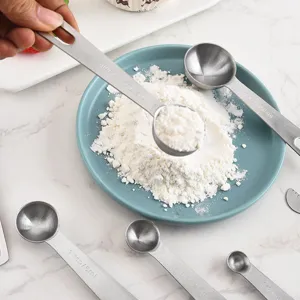 Stainless steel measuring spoons set with clear capacity markings, ideal for baking and kitchen use.