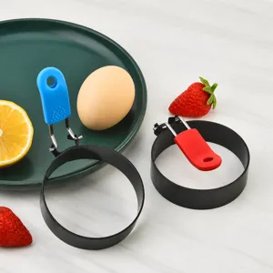 Stainless steel fried egg mold with folding silicone handle for breakfast cooking.